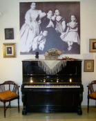Primer piano d'Alb�niz. A sobre una fotografia d'Alb�niz als dos anys d'edat amb la seva mare i les seves germanes. Conjunt situat al Museu Isaac Alb�niz de Camprodon